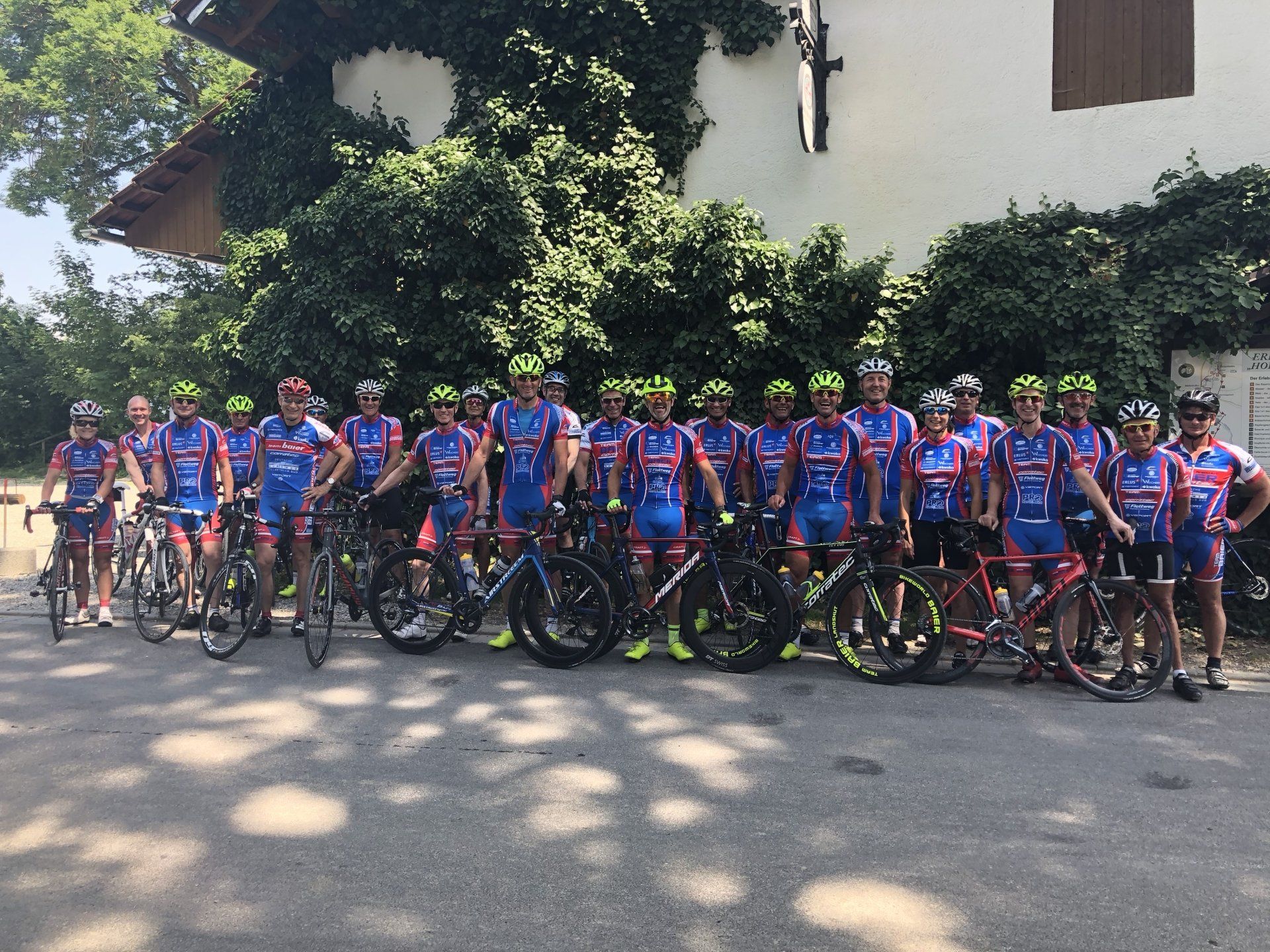 Eine Gruppe von Radfahrern posiert für ein Foto vor einem Gebäude