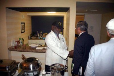 A man shaking hands with another man in a kitchen