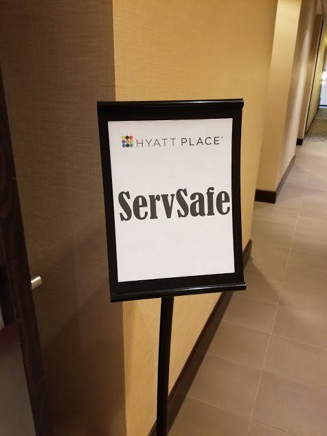 A sign in a hallway that says servsafe