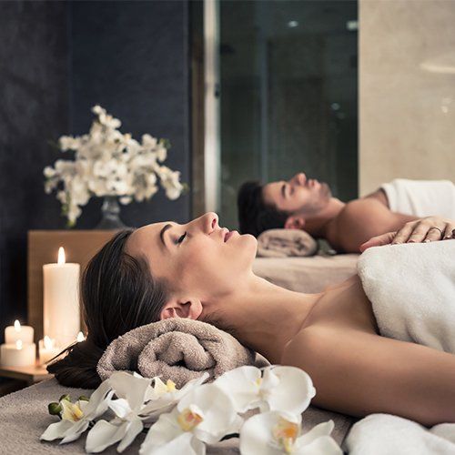 Man and Woman Lying Down on Massage Bed — Oceanport, NJ — Red Birch Spa Man and Woman Lying Down on Massage Bed — Oceanport, NJ — Red Birch Spa