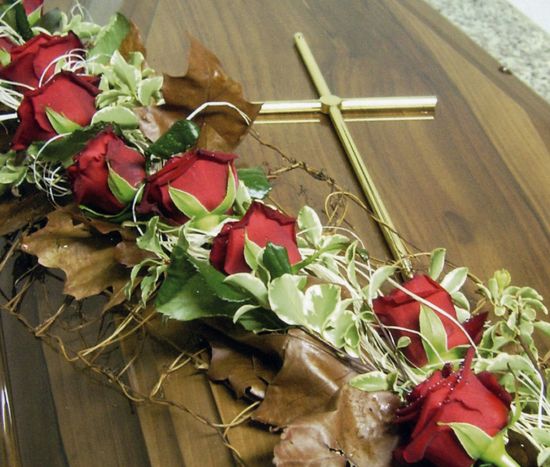 Composizione floreale con rose rosse per bara