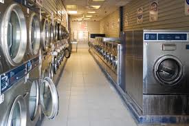 A laundromat filled with lots of washing machines and dryers.