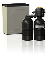 A water softener with two bottles attached to it is sitting next to a box.
