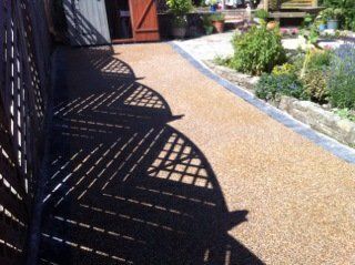 fence shadow across paved pathway