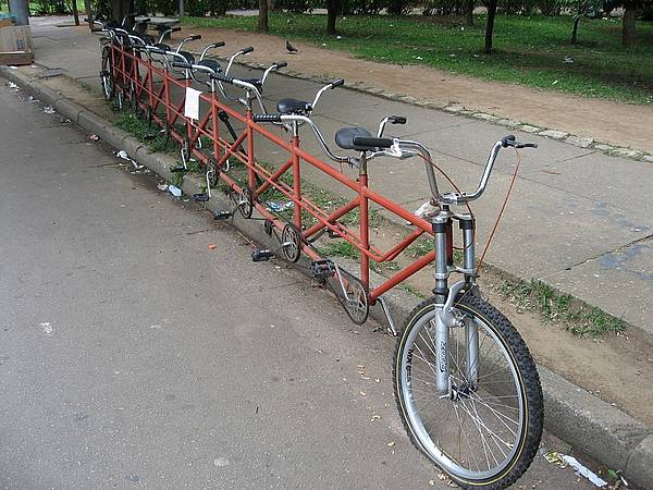 Foto von einem Tandem mit zehn Sitzplätzen, Lenker und Pedalparen. Allerdings mit Platten.