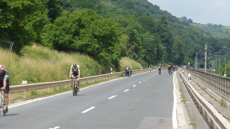 Foto von der Fahrbahn an der Loreley entlang. Zu sehen sind nur Radfahrer, keine Autos