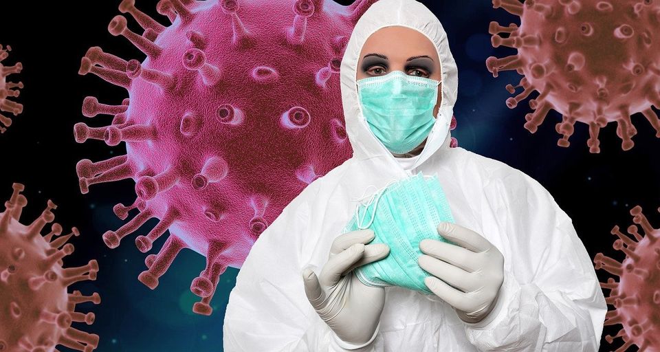 Symbolfoto von einer Dame in kompletter Schutzanzug mit einer medizinischer Maske auf und weiteren Masken in der Hand. Im Hintergrund sind riesige Viren abgebildet.