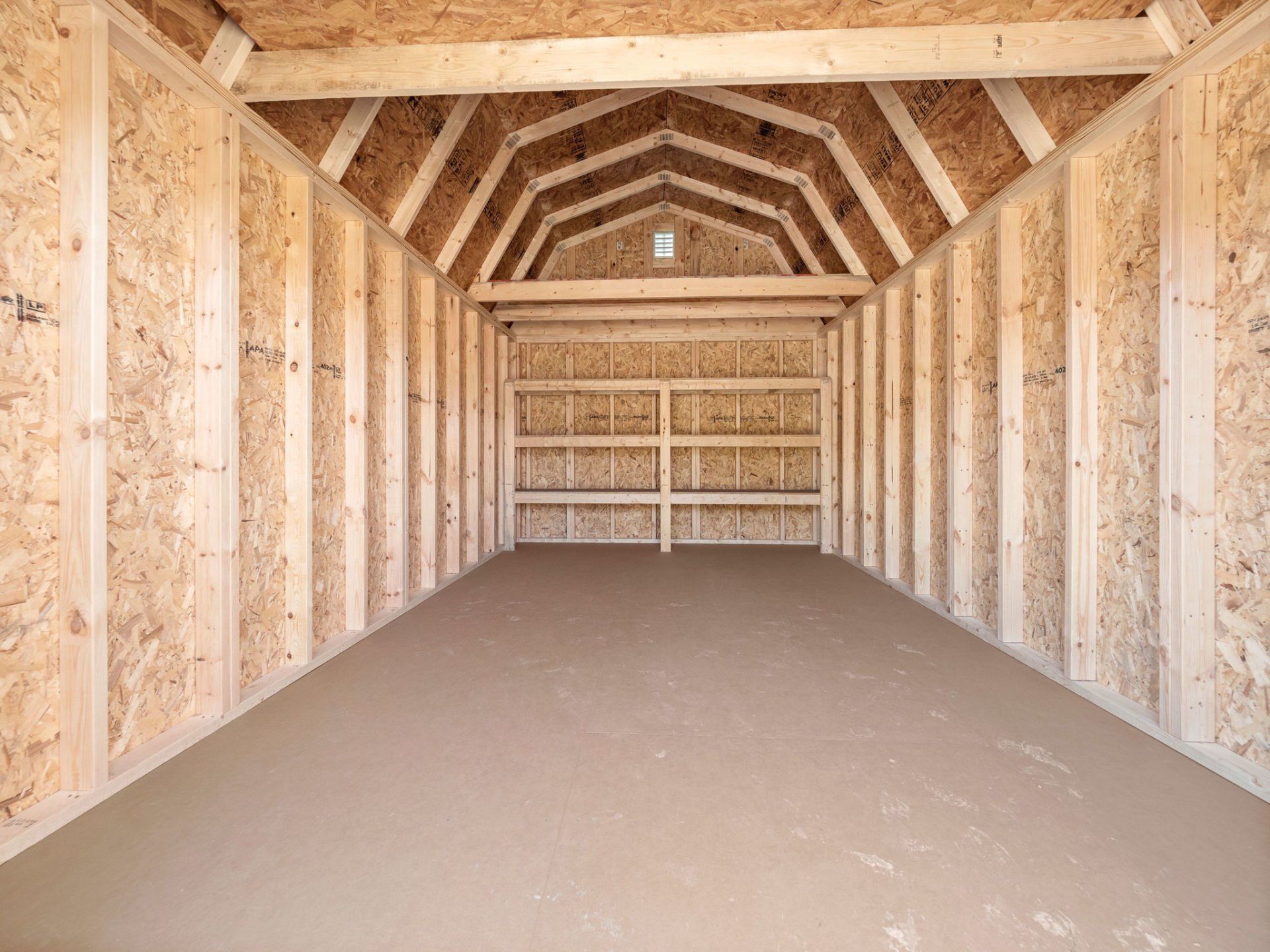 The inside of an empty wooden garage with a door.