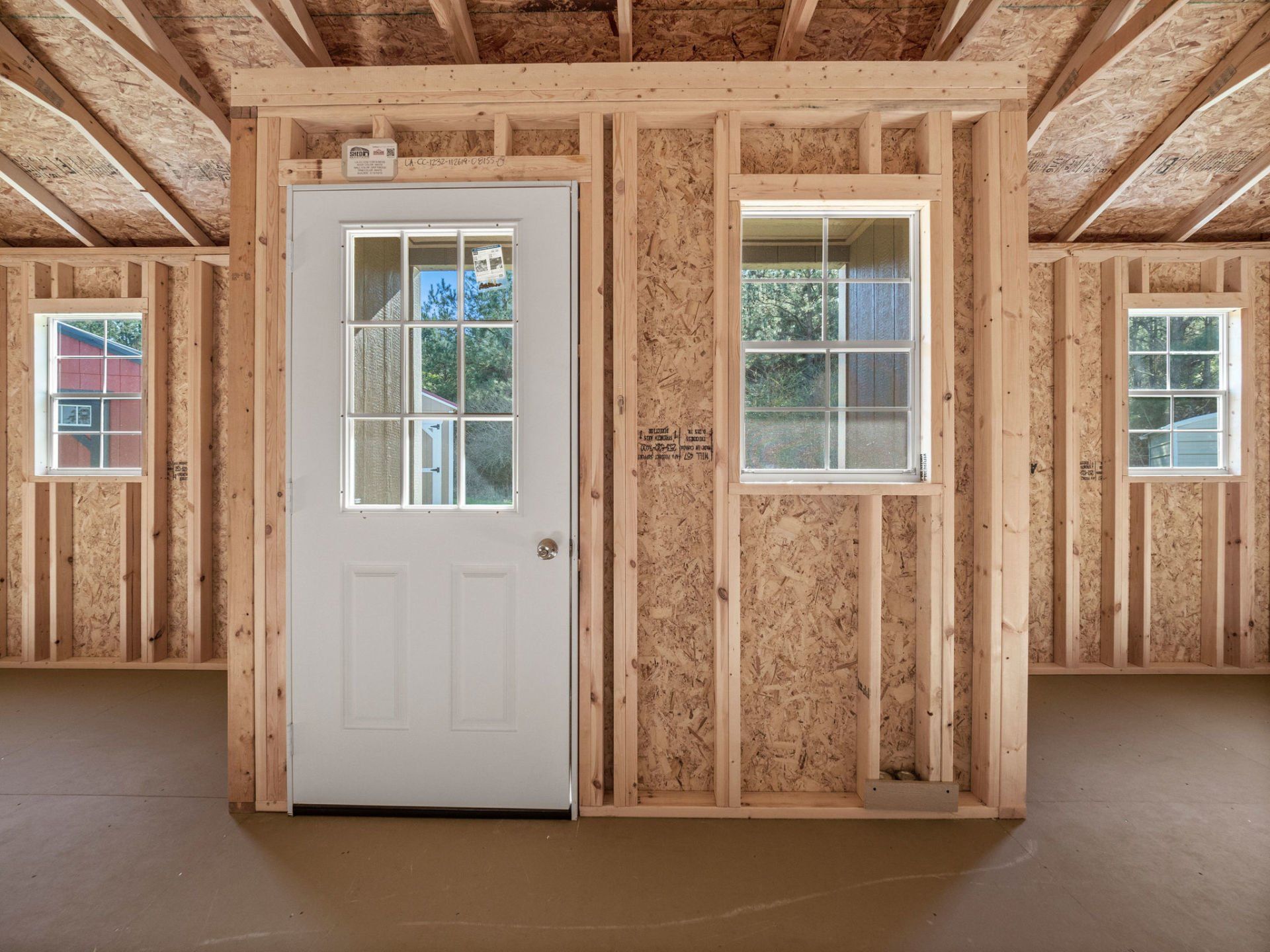 Inside of a shed with a door and three windows