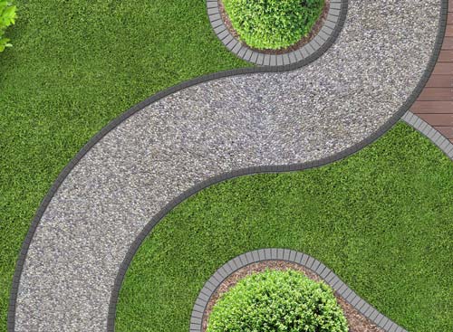 Overhead view of a winding gravel path bordered by green grass and brick edging; small shrubs.