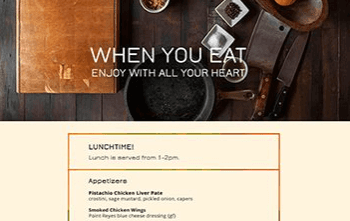 Wooden table setting with “WHEN YOU EAT, ENJOY WITH ALL YOUR HEART” above a lunch menu card
