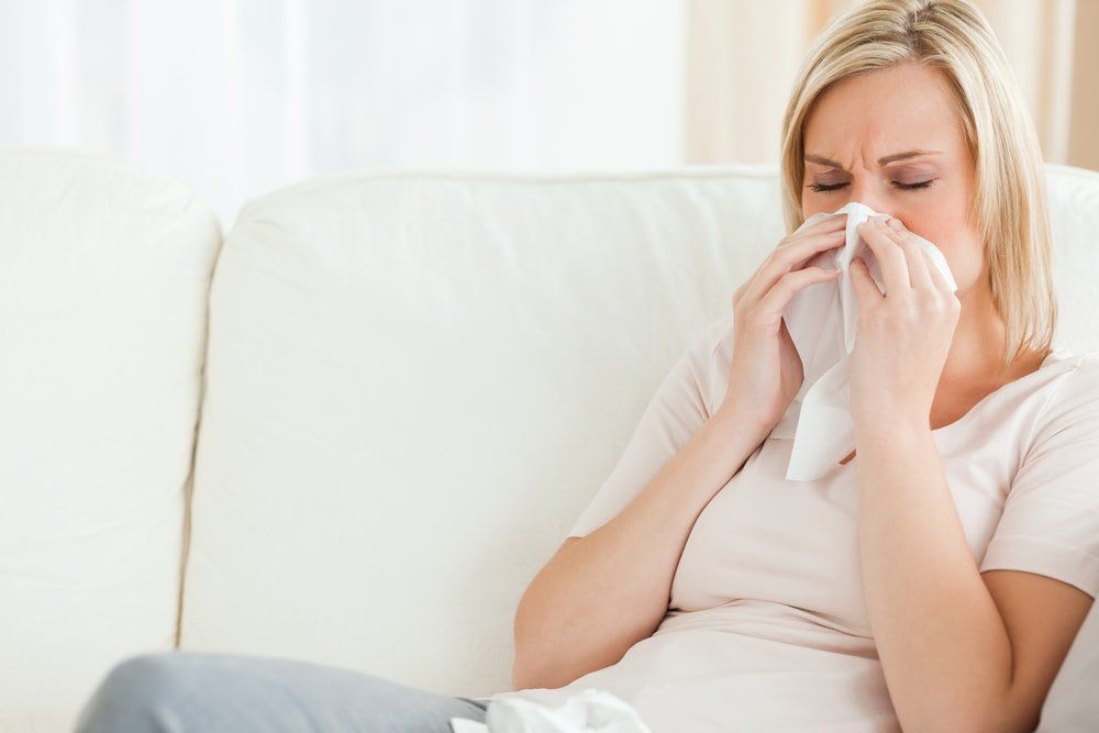 A female blowing her nose