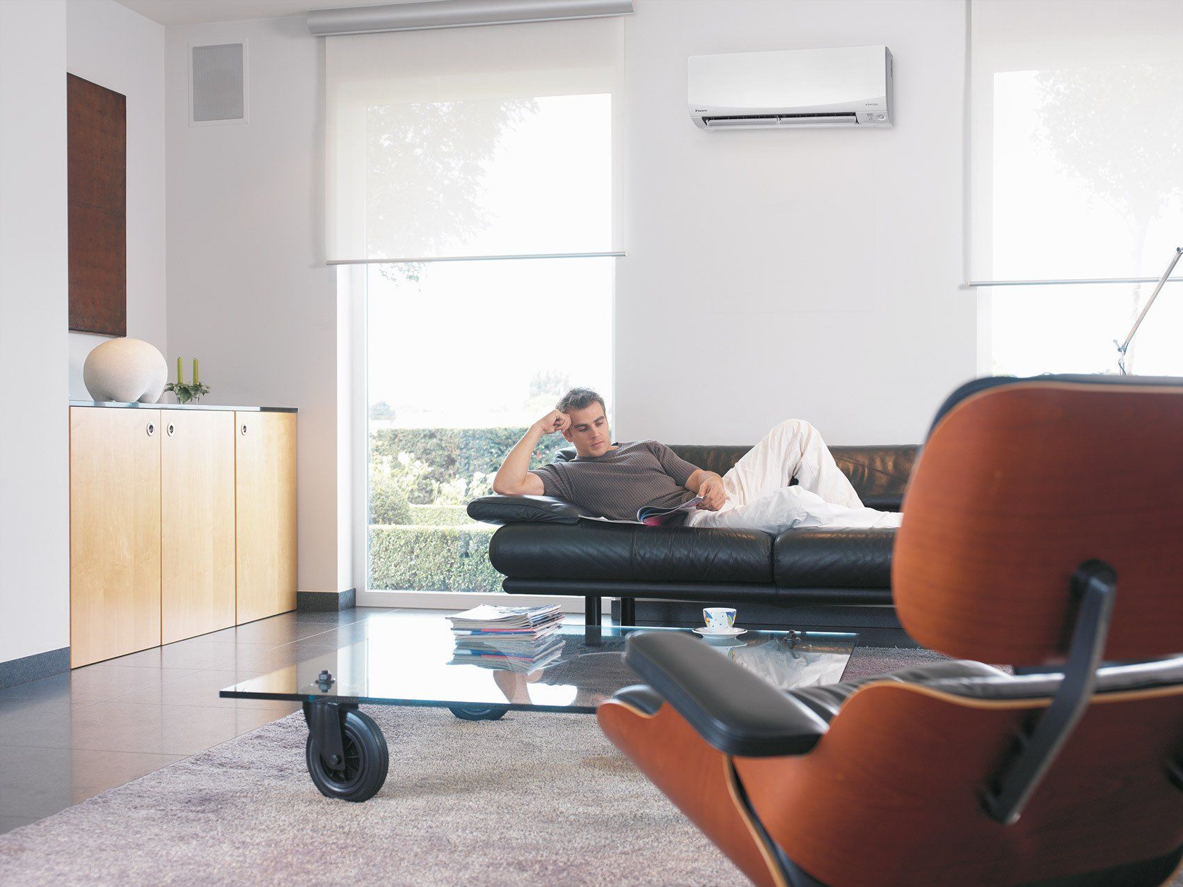Daikin heat pump in living room, man lying on sofa