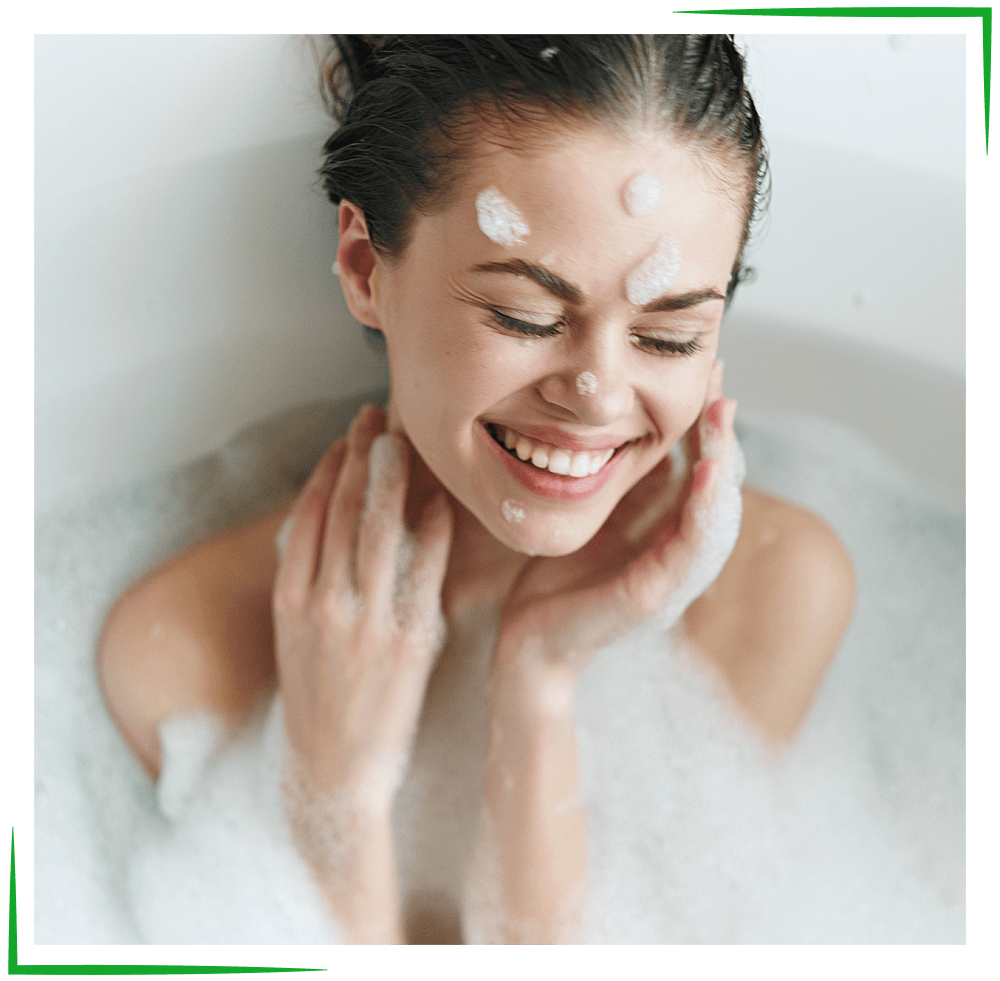 Walk-In Tubs - Missouri Bath & Window - Springfield, Missouri Woman in a bathtub with a facial treatment, smiling with eyes closed. Covered in bubbles.