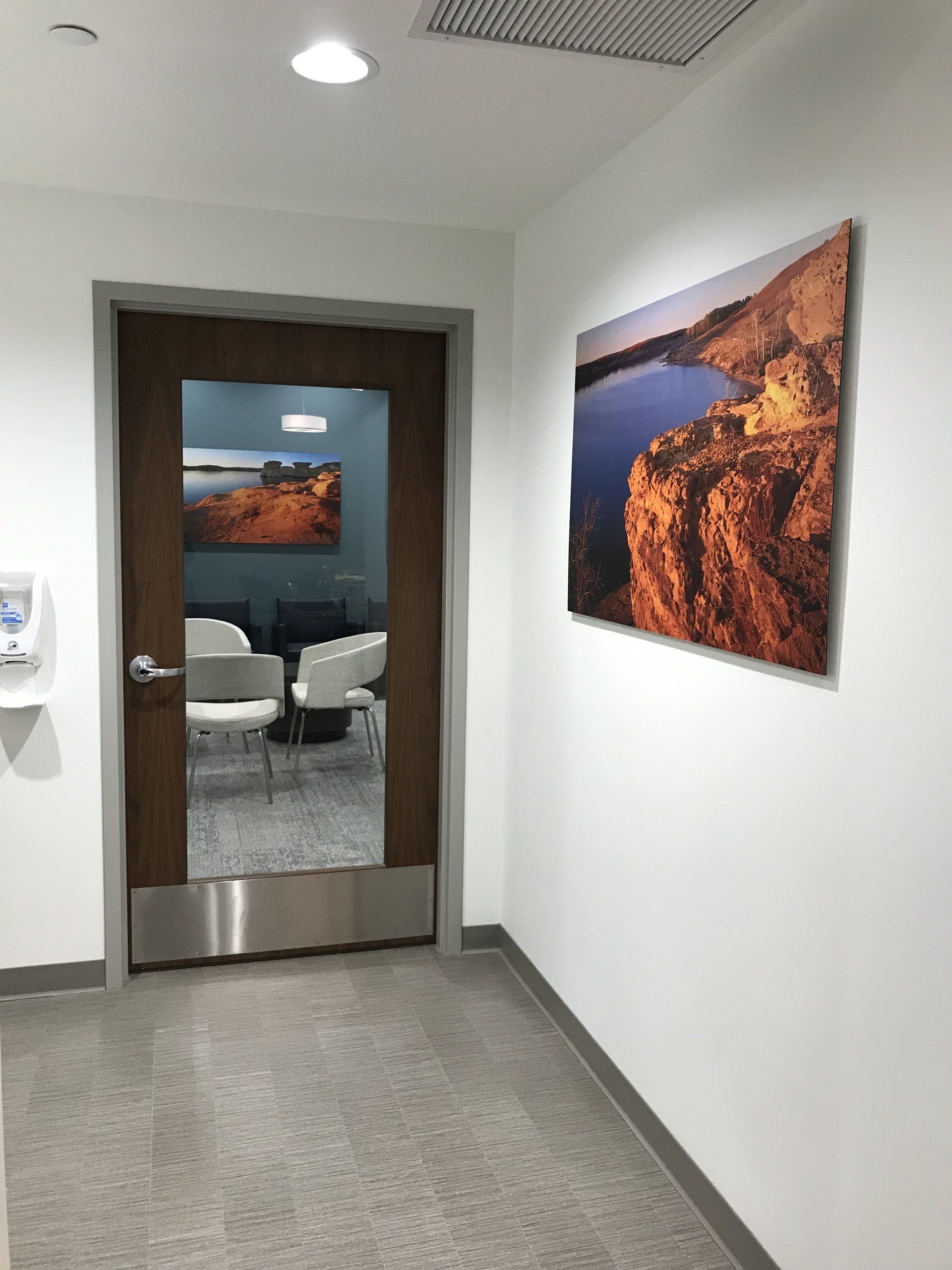 A hallway with a door and a picture on the wall
