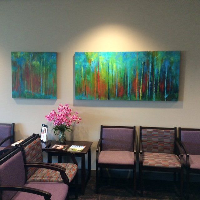 A waiting room with chairs and paintings on the wall