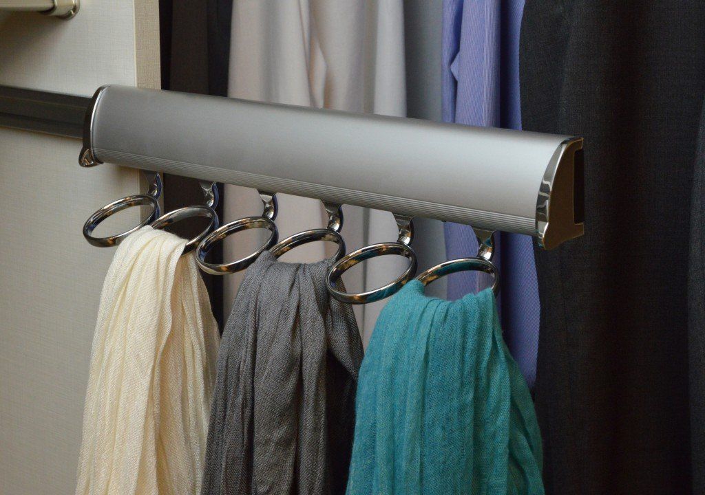 scarves are hanging on a rack in a closet