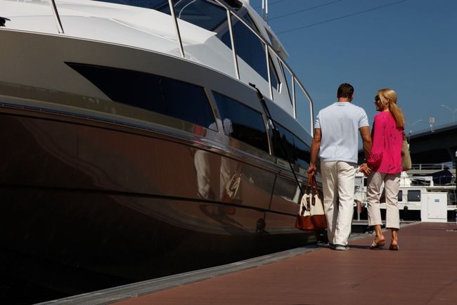A man and a woman are walking towards a boat