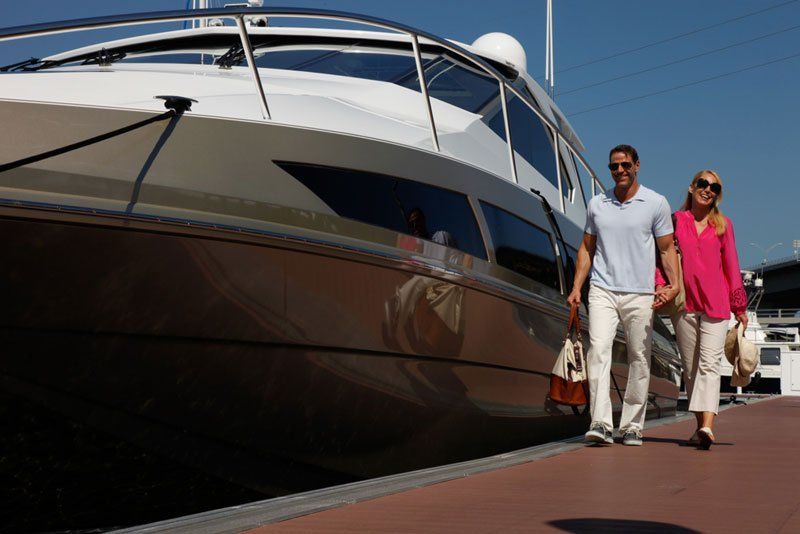 A man and woman are walking in front of a boat