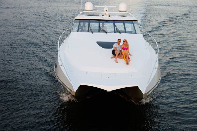 A man and a woman are sitting on the back of a boat.