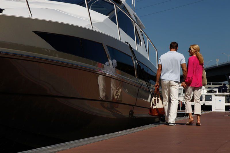 A man and a woman are walking towards a boat.