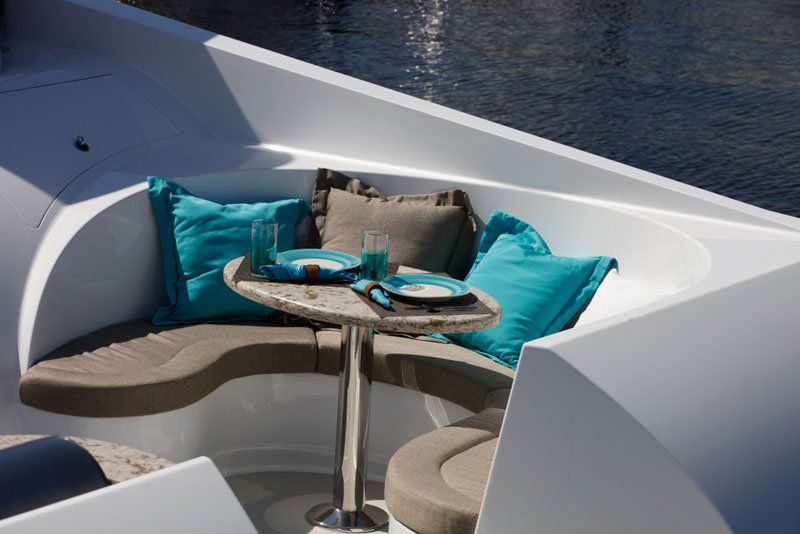 A boat with a table and blue pillows on it