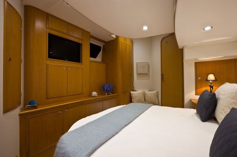 A bedroom on a boat with a large bed and a television.