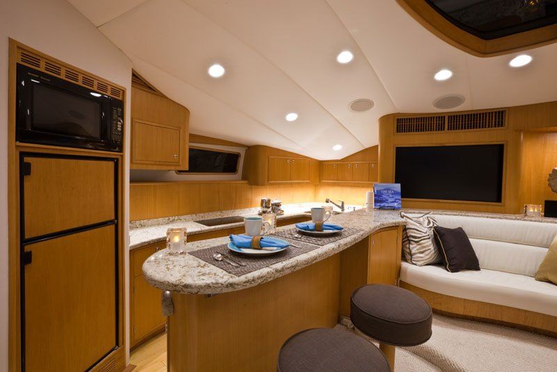 A kitchen on a boat with a couch and a television.