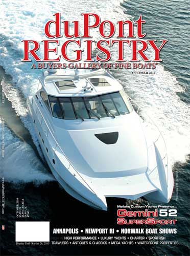 A white boat is on the cover of a magazine called dupont registry.