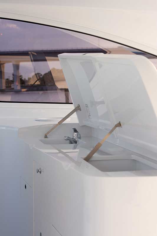 A white boat with the hatch open and a sink.