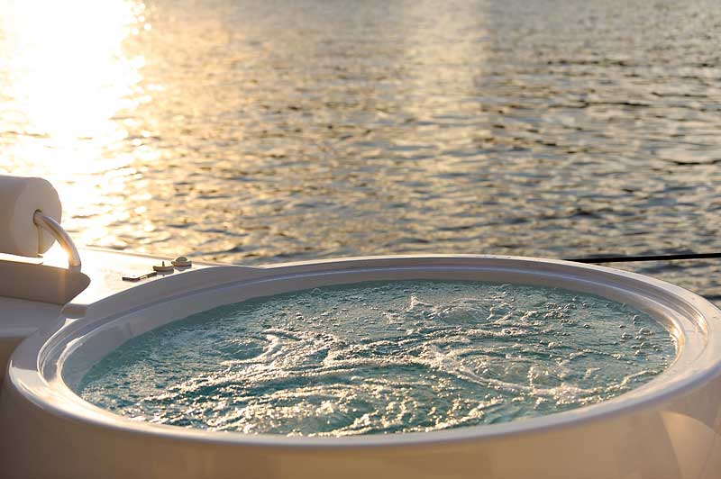 A bowl of water is sitting on a dock next to a body of water.