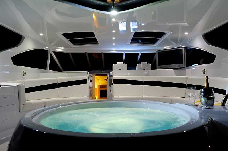 A jacuzzi on a boat with a bottle of champagne