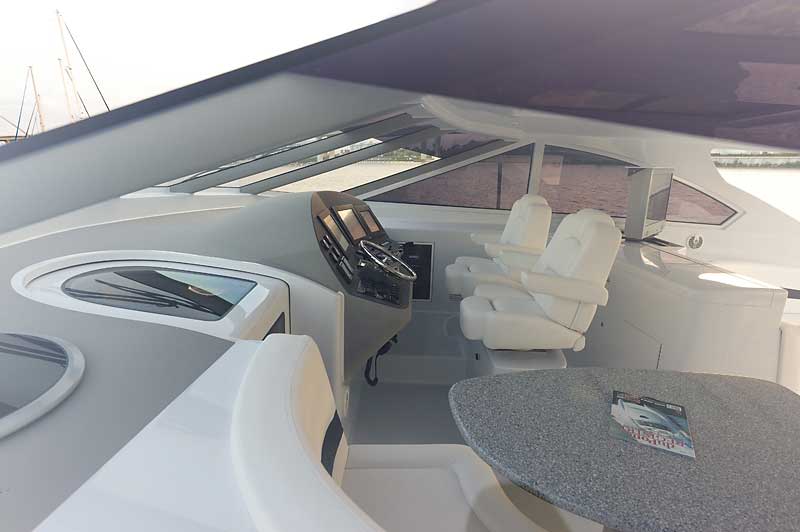 The inside of a boat with a table and chairs.