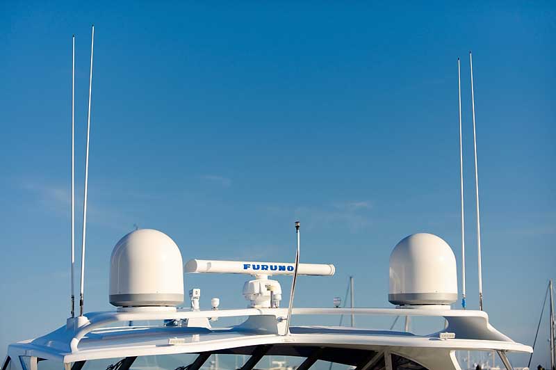 A boat with antennas on top of it and a blue sky in the background.