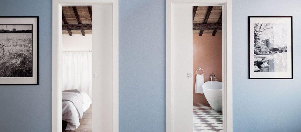 Corridoio con porte bianche e intonaco celeste chiaro