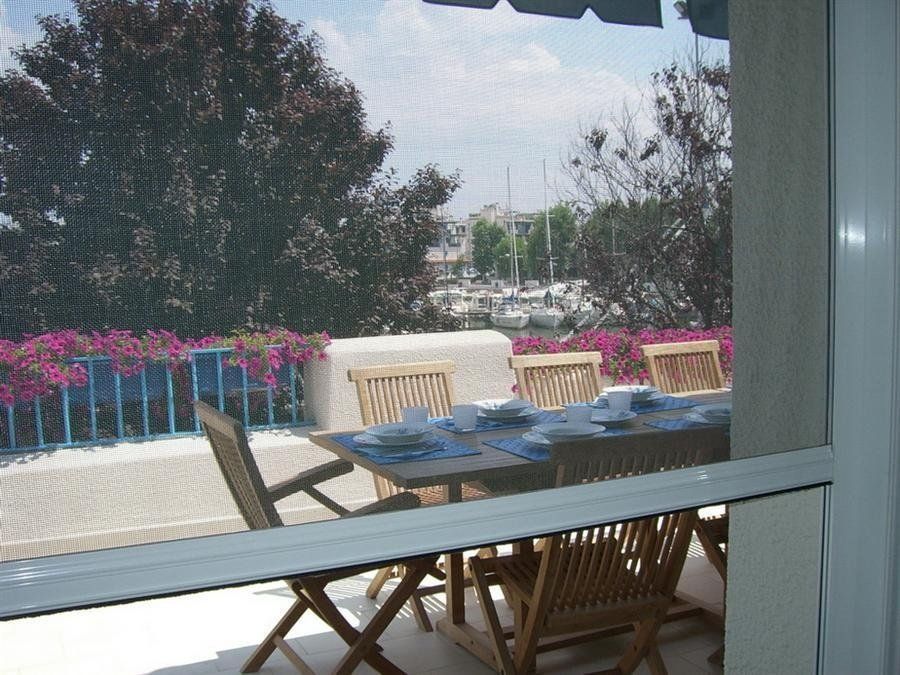 Terrazzo esterno con sedie in legno e balaustre azzurre