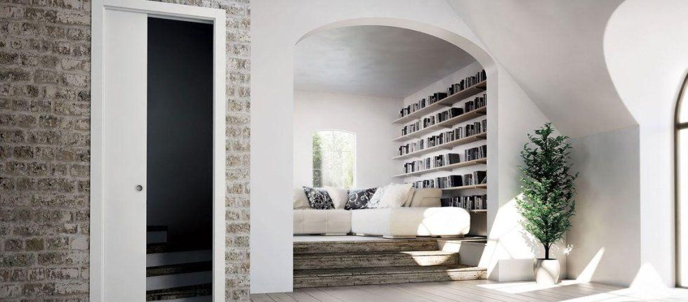 Salotto con divano bianco e libreria a muro