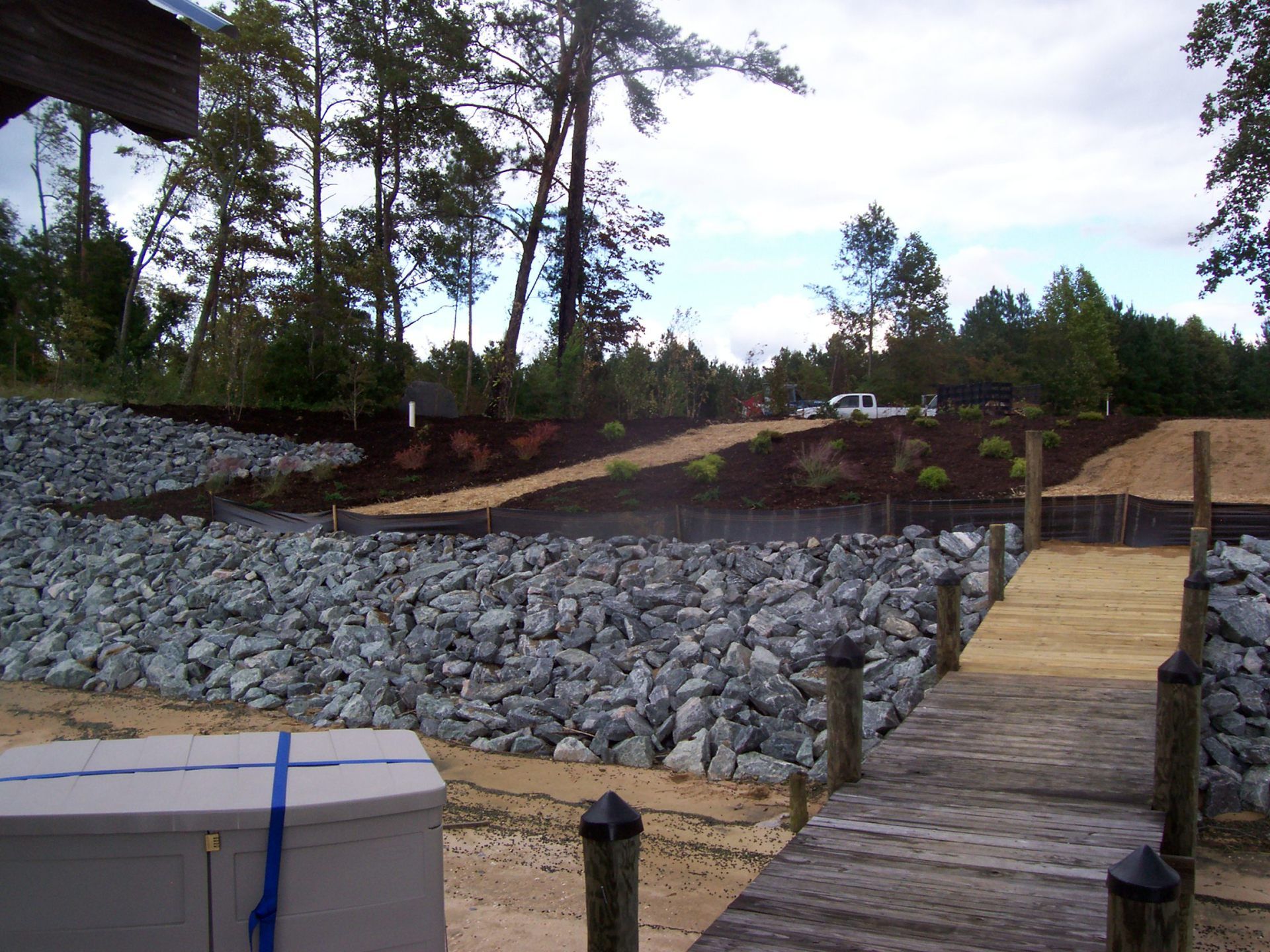 Rip Rap Service — Big Stones With Dock And Pickup Truck On Top Hill in Shacklefords, VA