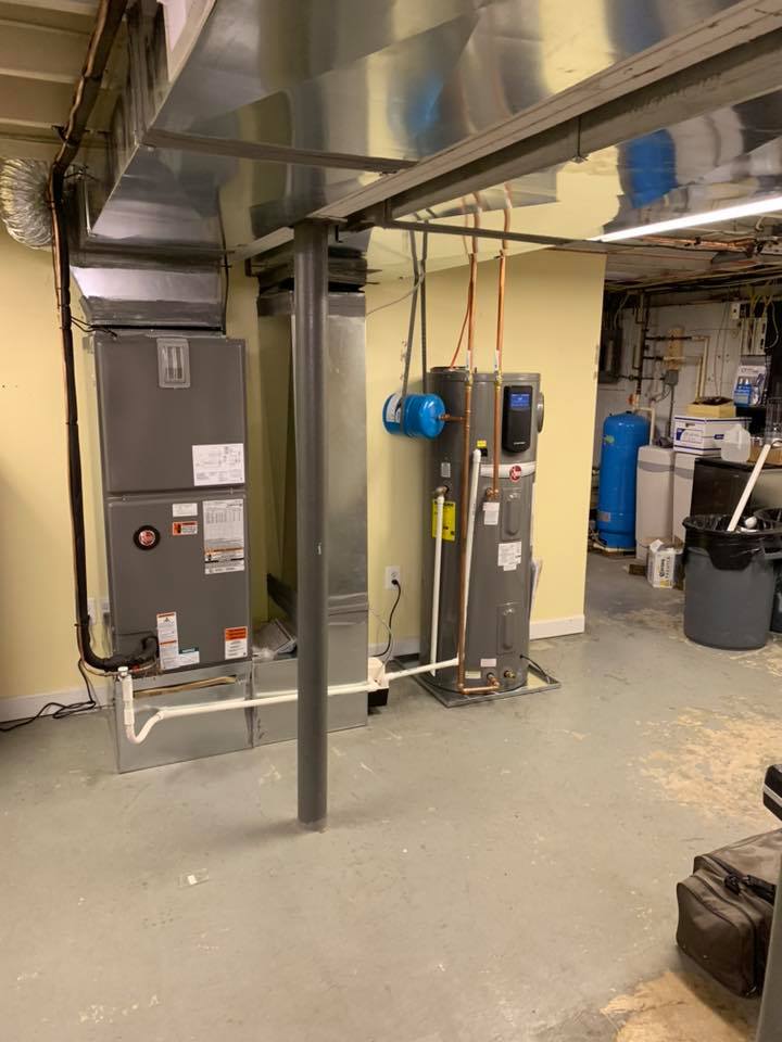Basement with HVAC system, water heater, ductwork, pipes, and support beams. Gray, white, and tan.
