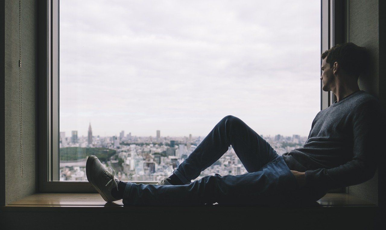 man sitting next to window film glass