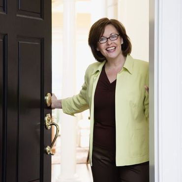 Woman Opening Her Front Door — Doors located in Las Vegas NV 89118