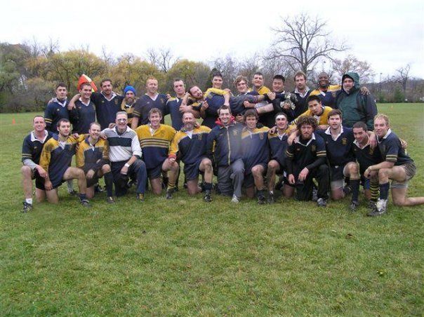 A group of men are posing for a picture in a field
