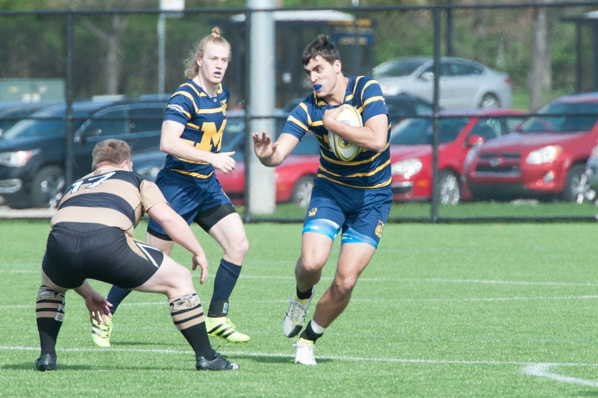 A group of men are playing rugby on a field.
