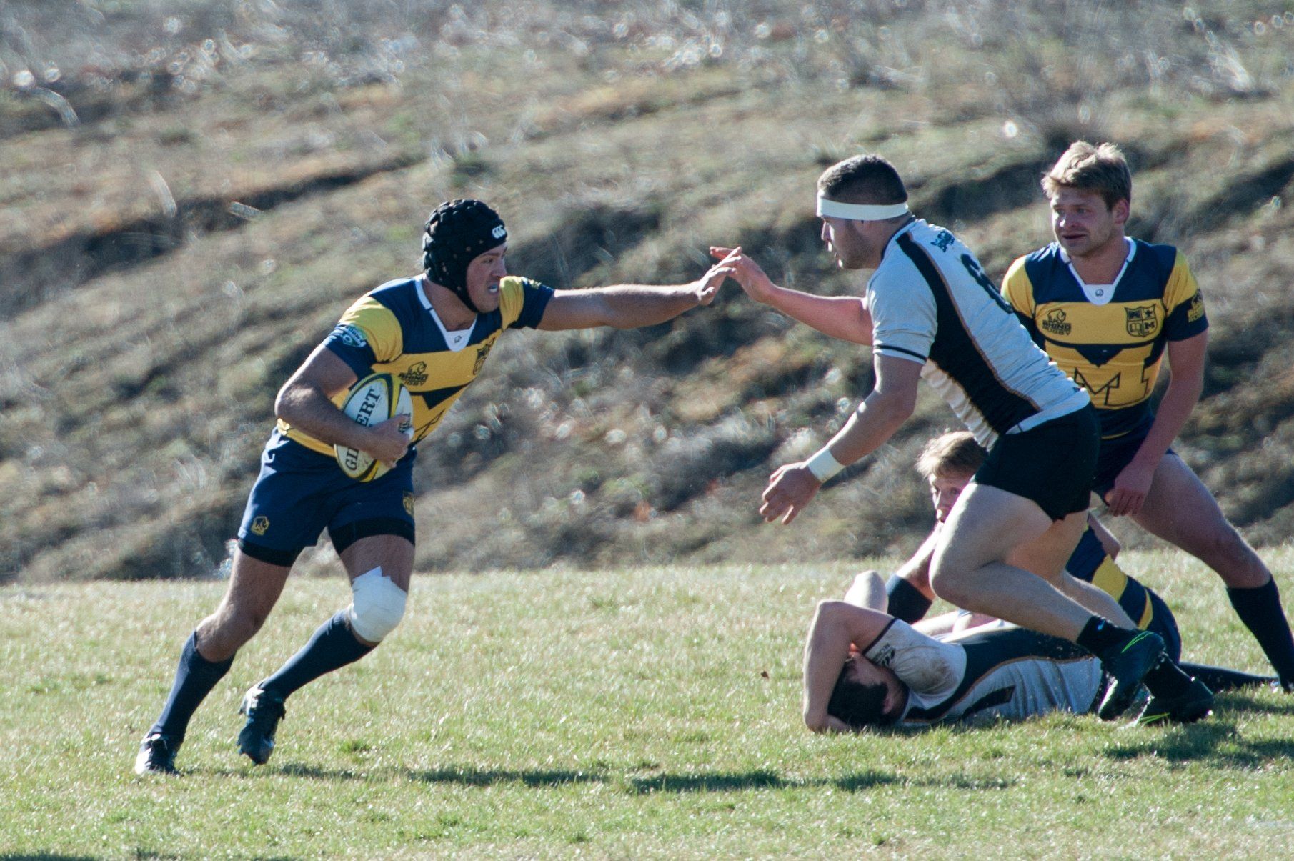 A group of rugby players are playing a game on a field.