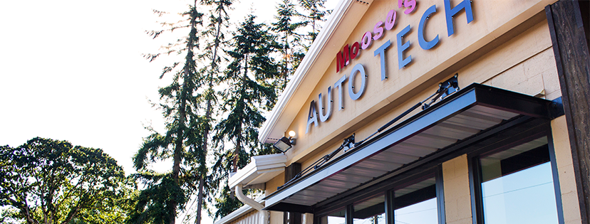 Exterior shot of Moosie's Auto Tech building with a sign, trees, and awning.