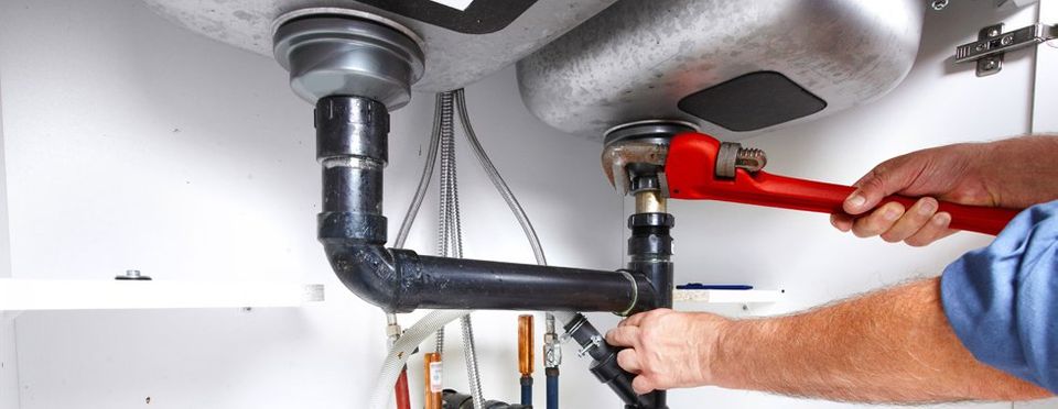 A plumber working underneath a sink
