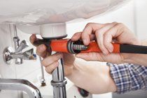 A plumber working underneath a sink