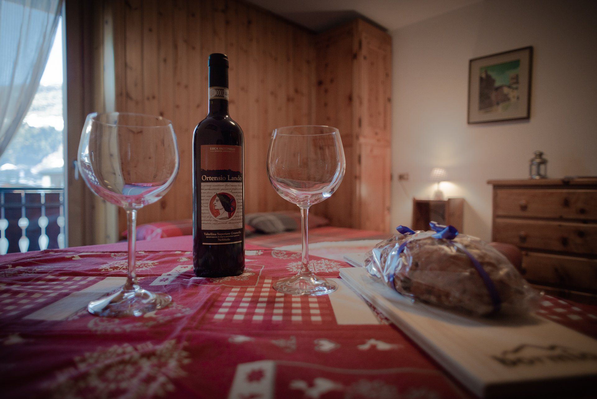 Su un tavolo ci sono una bottiglia di vino e due bicchieri di vino.