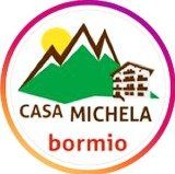 Il logo di casa michela bormio ha una montagna e una casa sopra.