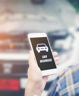 Car owner holding phone — Auto Insurance in Merrillville, IN Car owner holding phone — Auto Insurance in Merrillville, IN